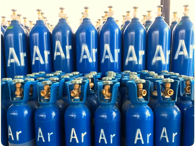 Rows of blue argon (Ar) gas cylinders with brass valves