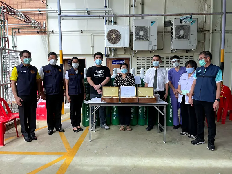 Group photo of the team and recipients in front of a table with oxygen equipment sets